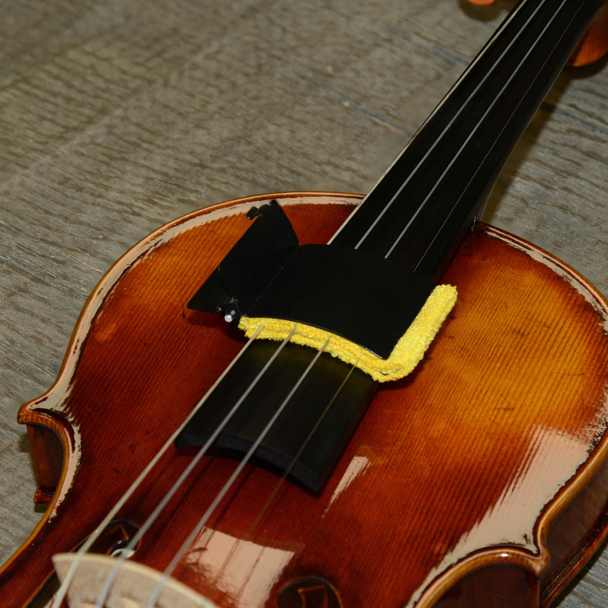 Tonegear violin string cleaner with microfiber cloth put to use cleaning the strings on a violin