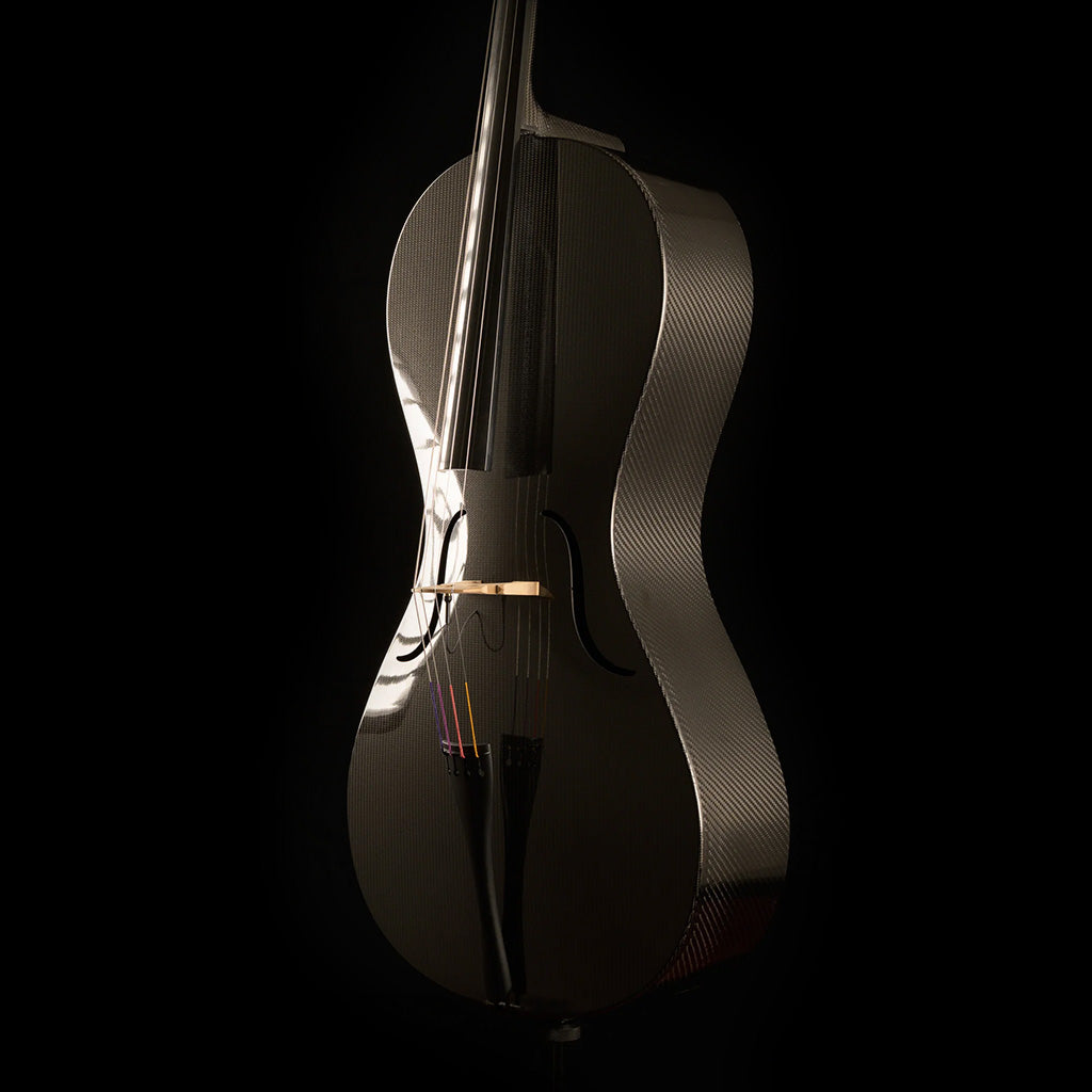Three-quarter view of a Mezzo-Forte carbon fiber cello from the right, showing the woven carbon ribs, glossy top, and black tailpiece, on a black background.