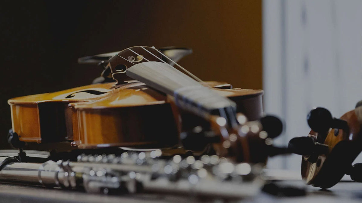 Violins and flutes resting on a table near a window