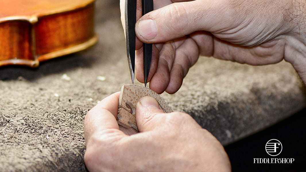 Luthier measuring the string grooves on a violin bridge